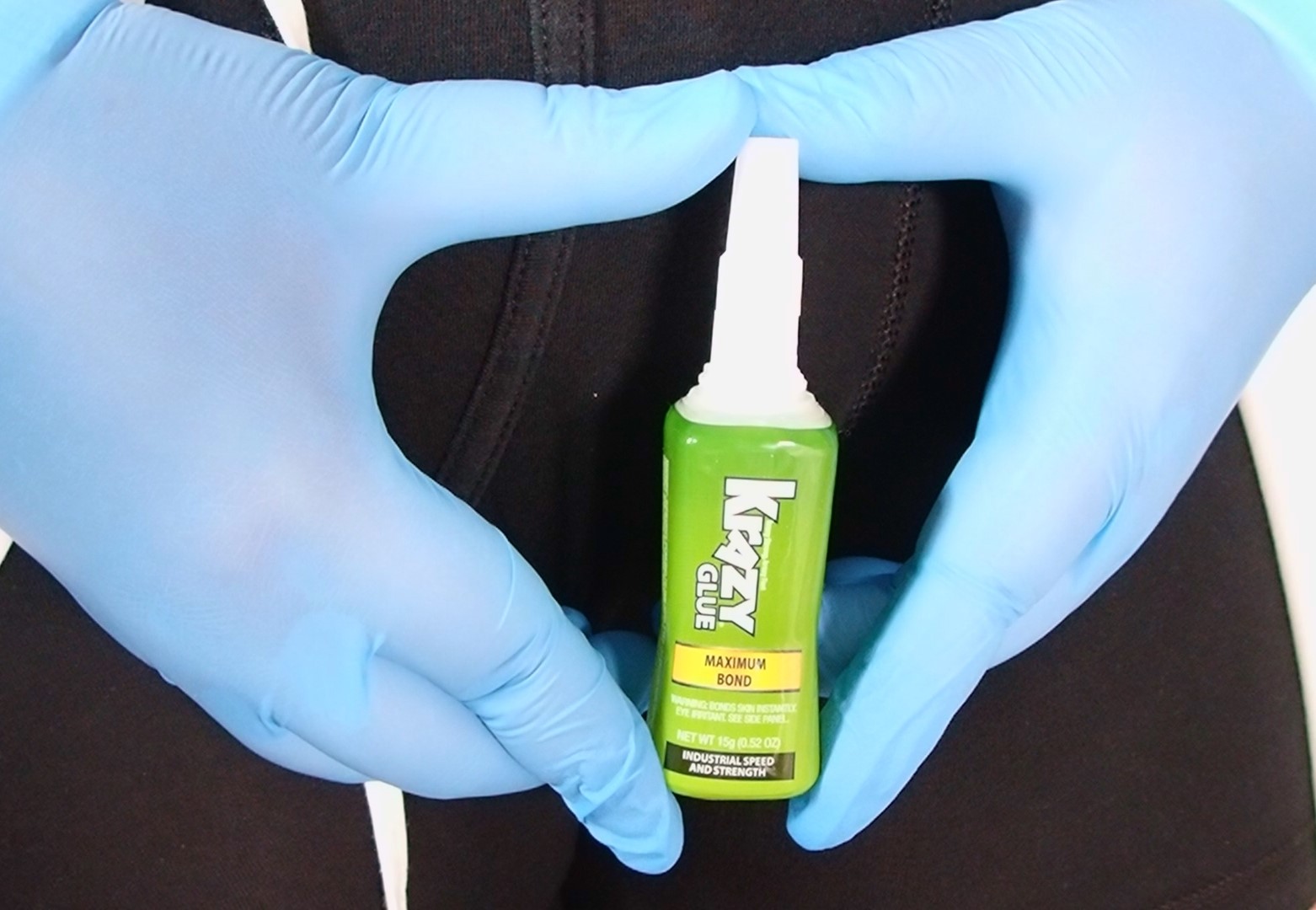 I'm wearing boxer briefs, a lab coat, and blue exam gloves while holding krazy glue